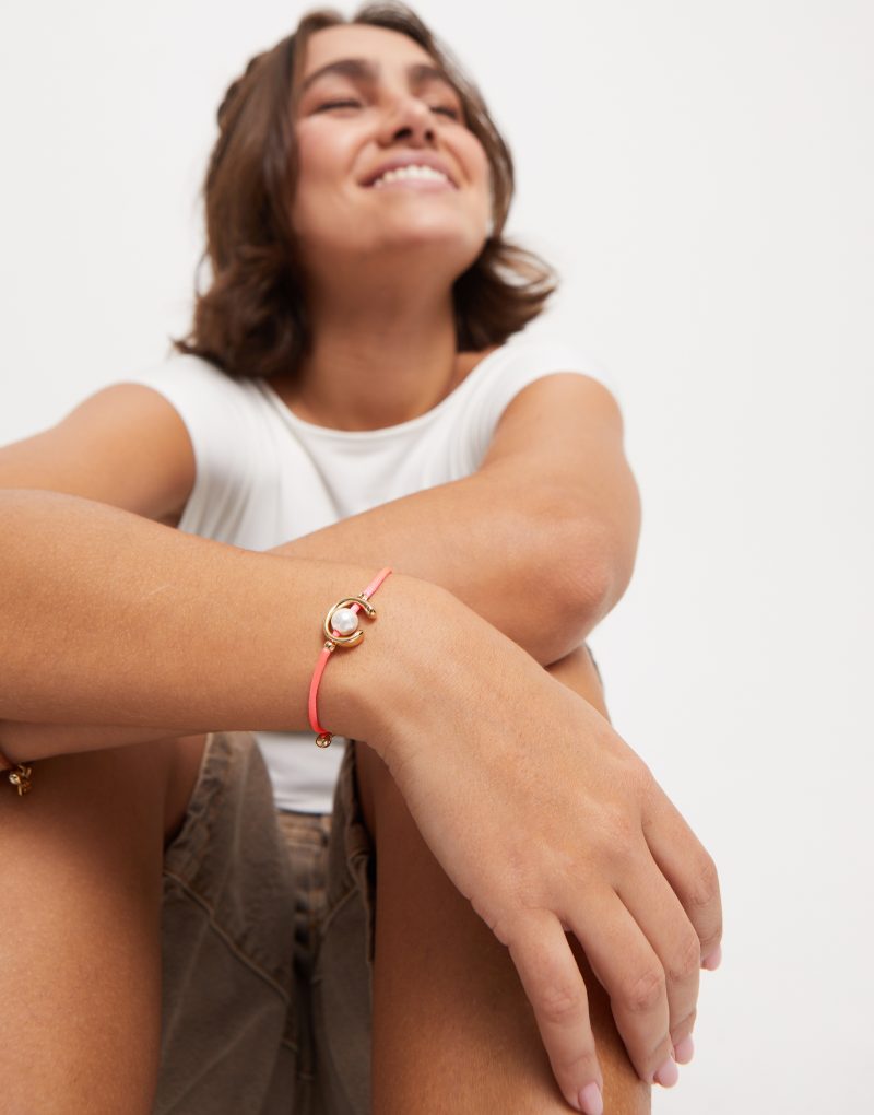 Pulsera de hilo fucsia con perla shell fornitura bañada en oro 18k. - Imagen 2